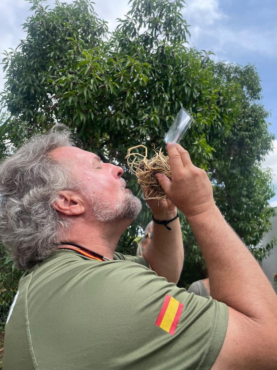Lobo, instructor de White Neck, sopla un nido de yesca en un taller de fuego