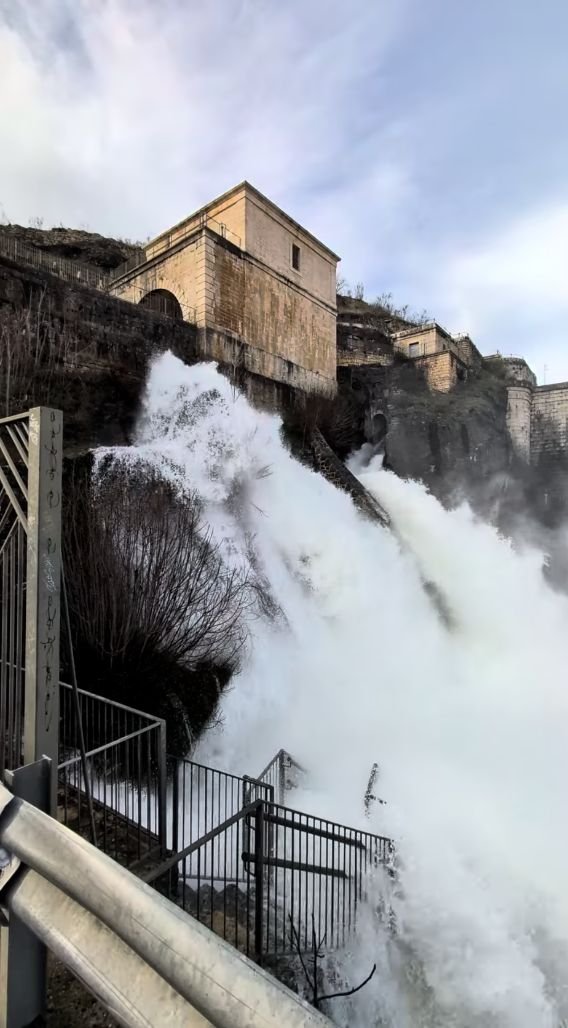 Presa del Pontón de la Oliva soltando agua, con su casa de guardia